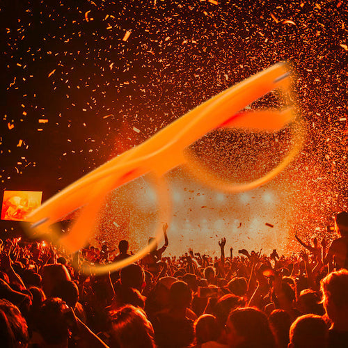 Crowd feestend tijdens Koningsdag met oranje confetti en grote oranje bril als Koningsdag versieringen